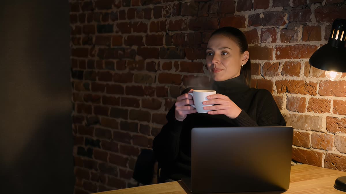 She sits back from her laptop with a cup of tea, looking out into the evening